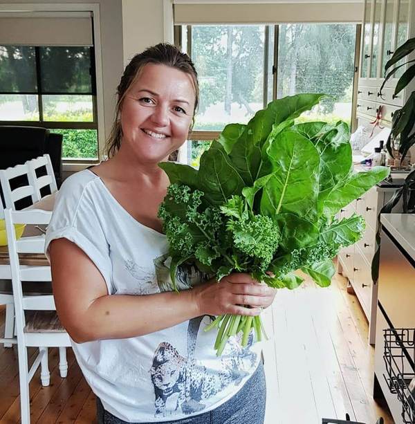 Zdenka, founder of Planting Organics, holding freshly grown spinach