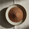 Ceramic bowl with honeybush glanulated tea on a textured beige surface